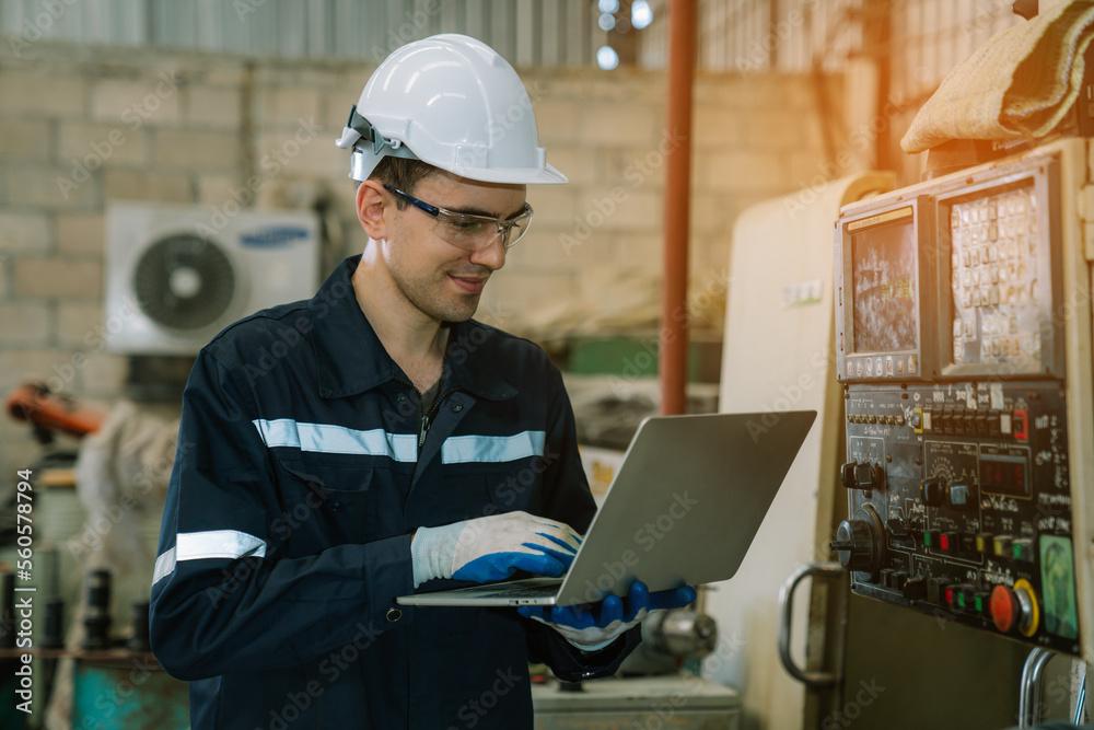 Field engineers using a laptop to service a machine on the plant floor